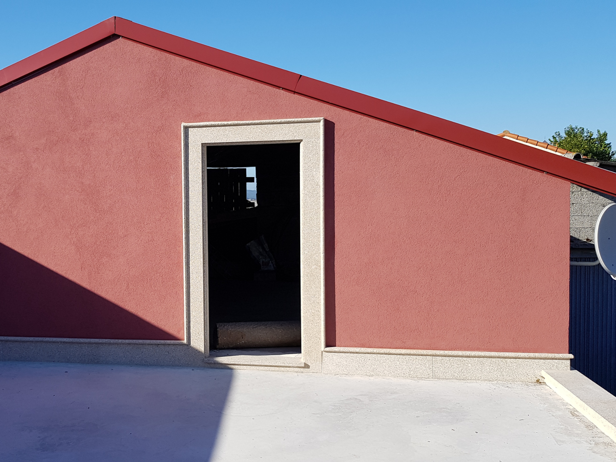 Fachada de vivienda pintada en rojo terracota, resultado final del trabajo