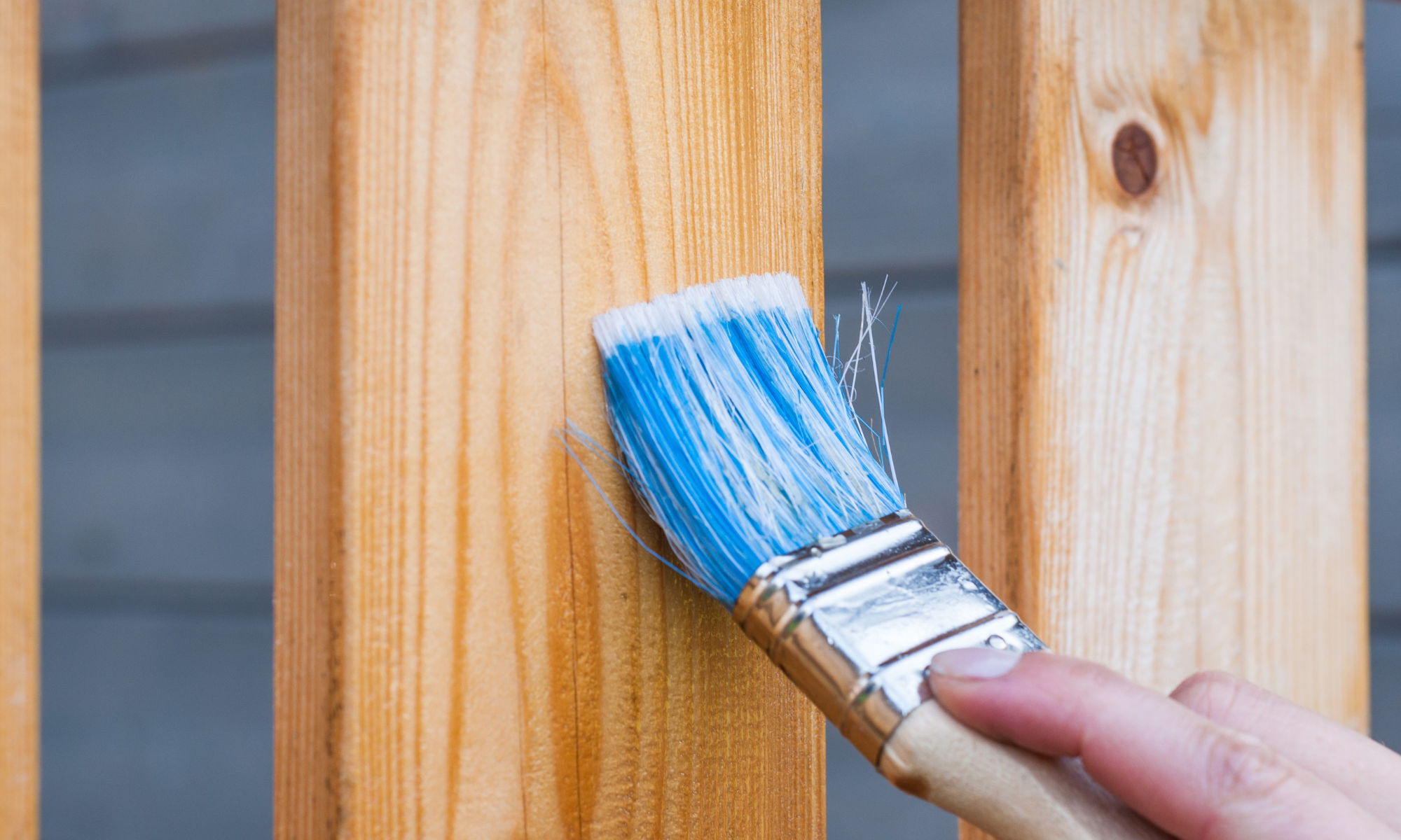 Aplicación de tratamiento protector con brocha sobre madera de exterior